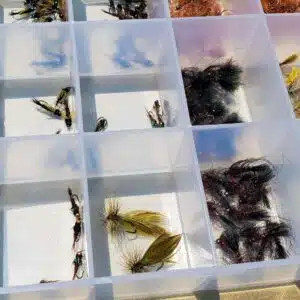 A clear fly box from an Eastern Sierra Fishing Guide full of fly fishing flies.