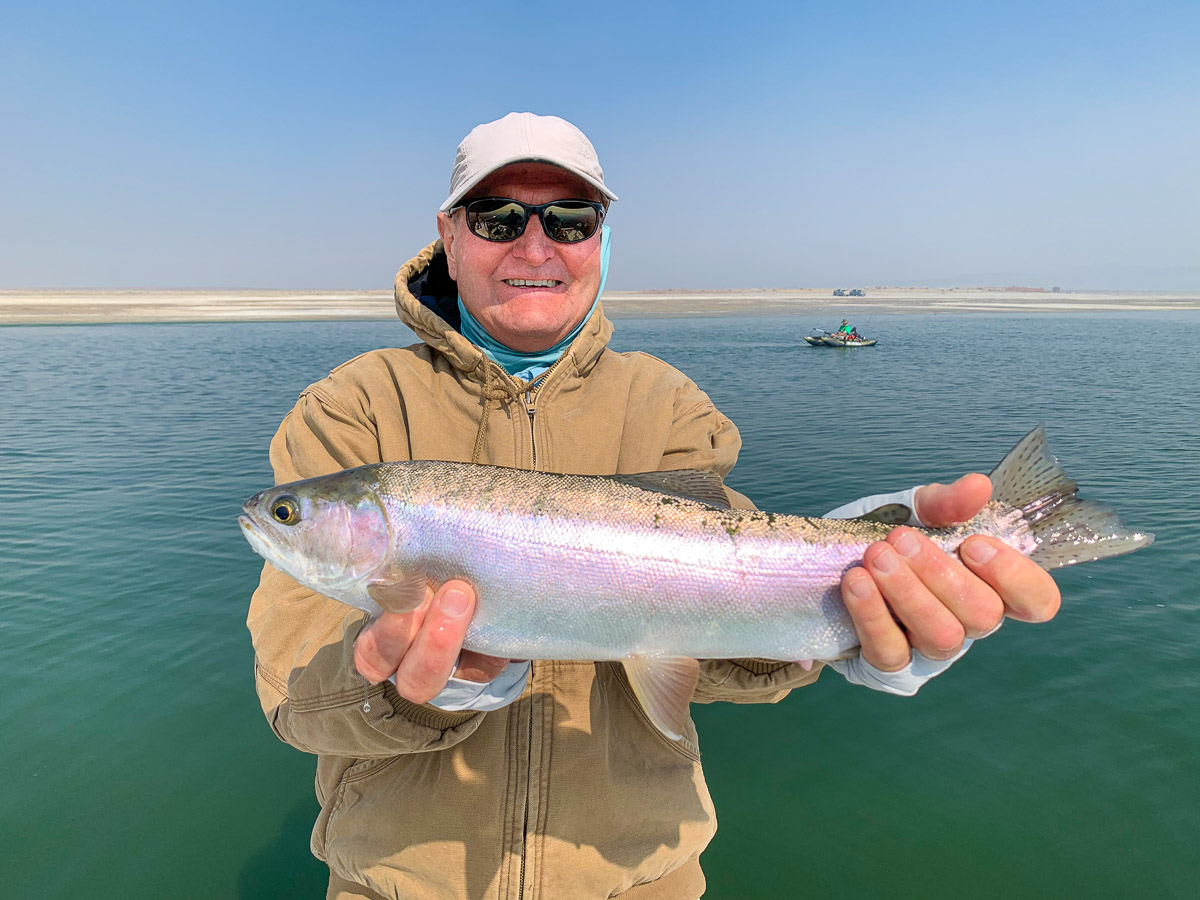 A fly fisherman holding a rainbow trout from Crowley Lake.