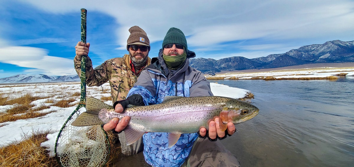 A fly fisherwomman holding a rainbow trout during the fall spawn from the Upper Owens River.