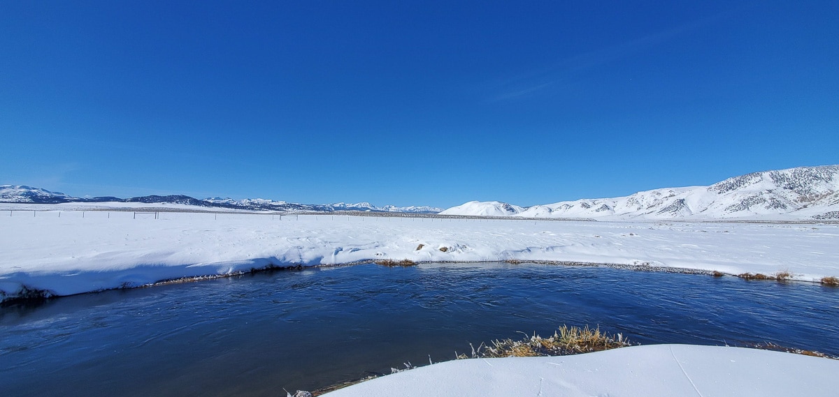 The Upper Owens River in the winter with snow all around.