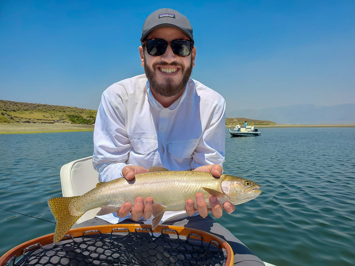 A fly fisherman holding a cutthroat trout from Crowley Lake.