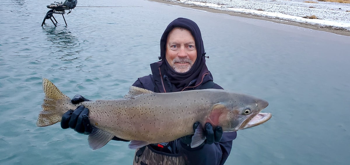 A gentleman with a large fish in a boat.