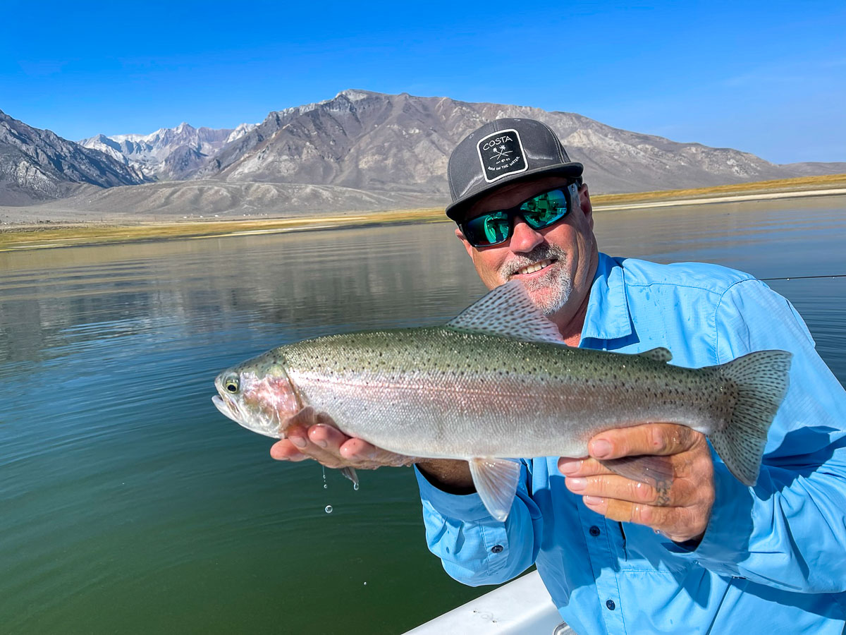 A man holding a massive rainbow trout on Crowley Lake.
