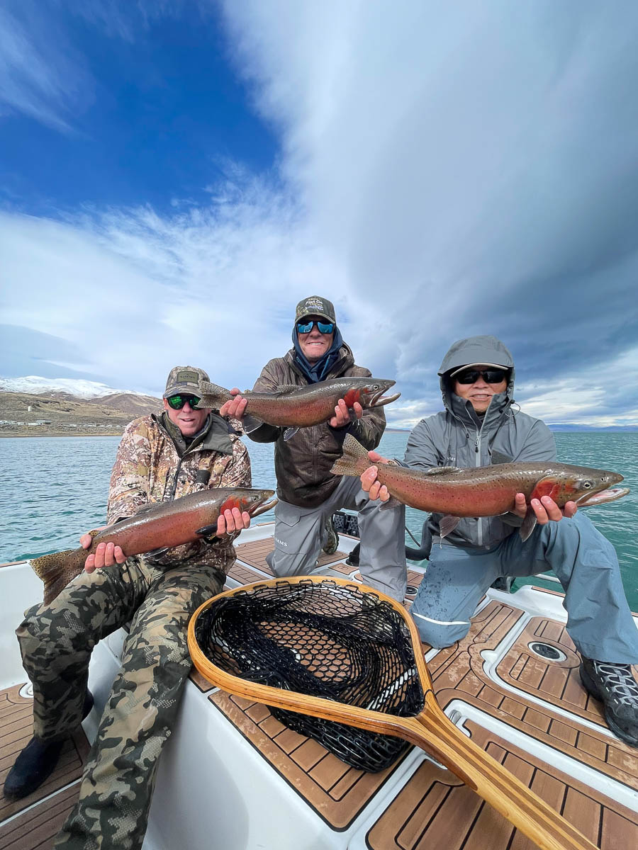 A trio of fishermen with a trio of monster sized cutthroat trout on a boat on Pyramid Lake.