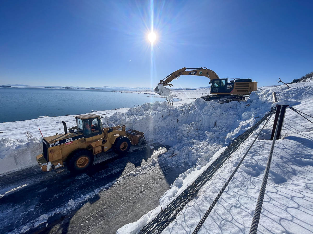 Road construction equipment clearing an avalanche from US Highway 395 in Lee Vining, CA.