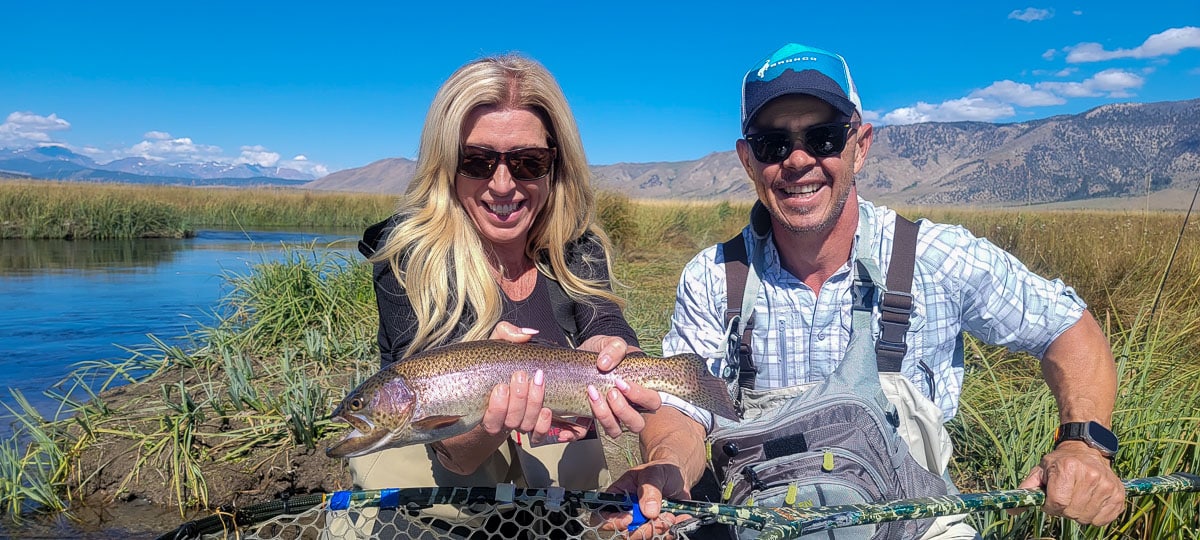 A fisherwoman holding a large rainbow trout from the Upper Owens River.