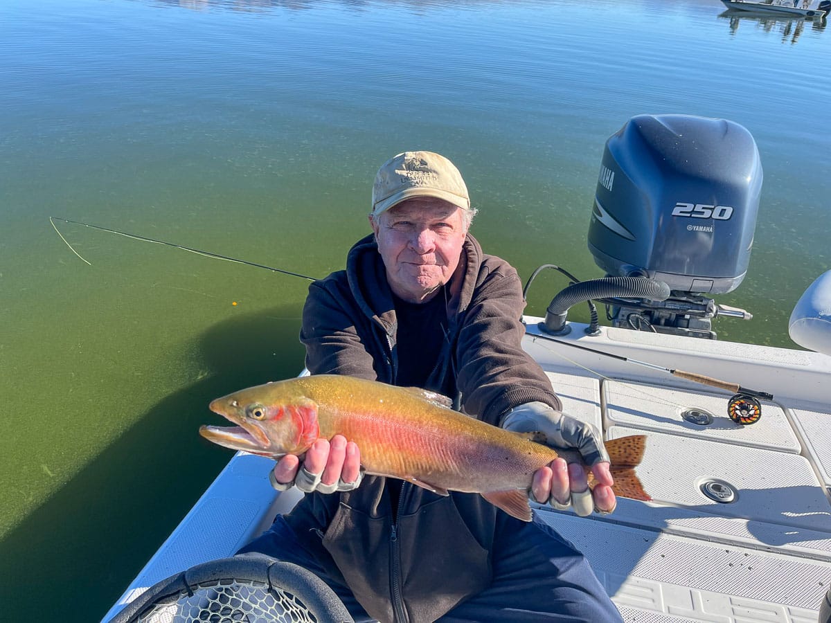 A fisherman holding a large cutthroat trout from Crowley Lake.