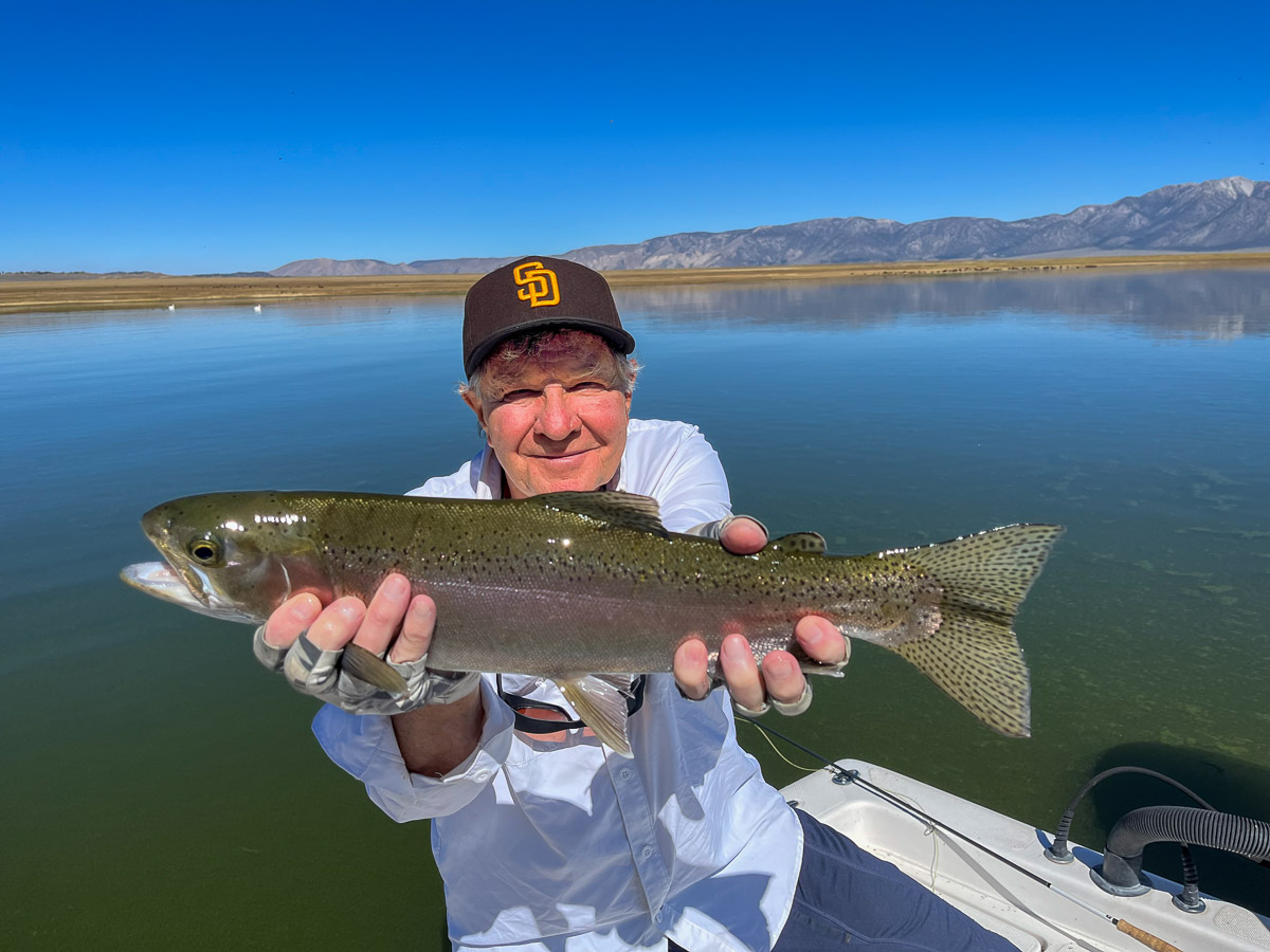 A fisherman holding a large rainbow trout from Crowley Lake.