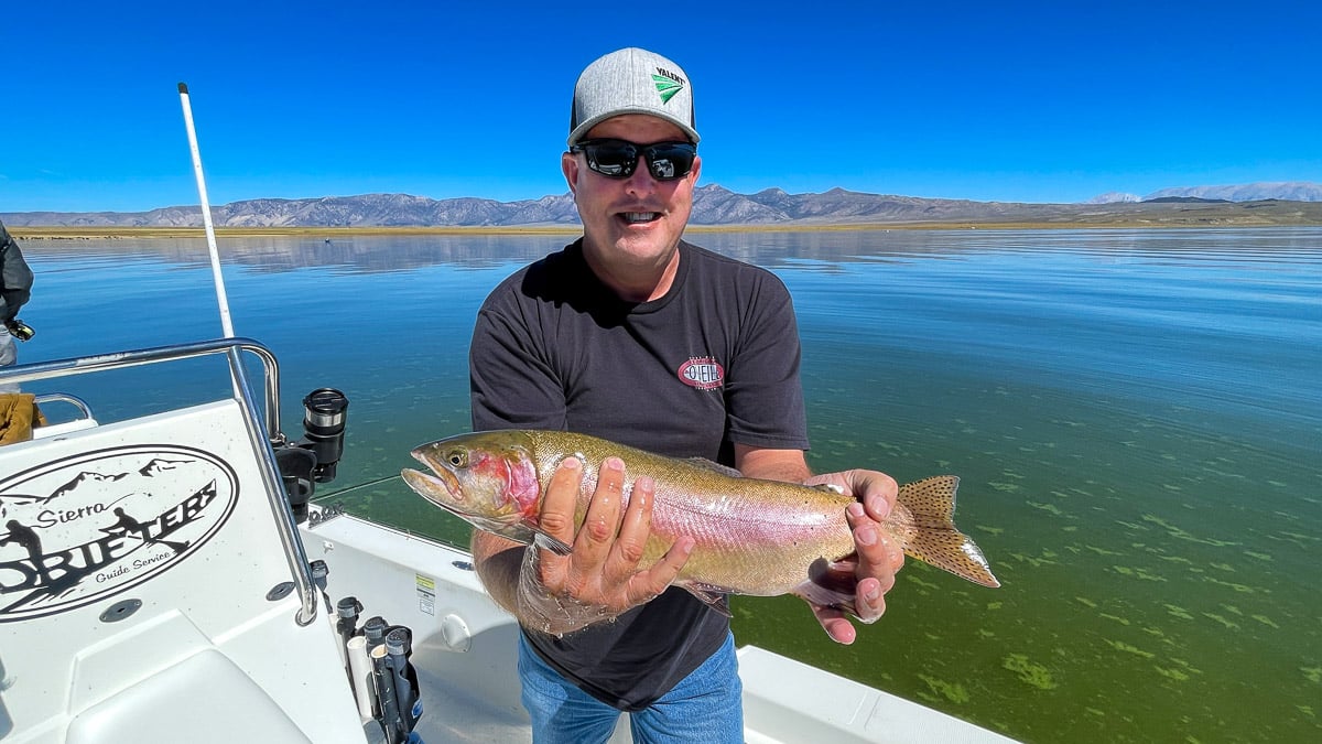 A fisherman holding a large brown trout from Crowley Lake.