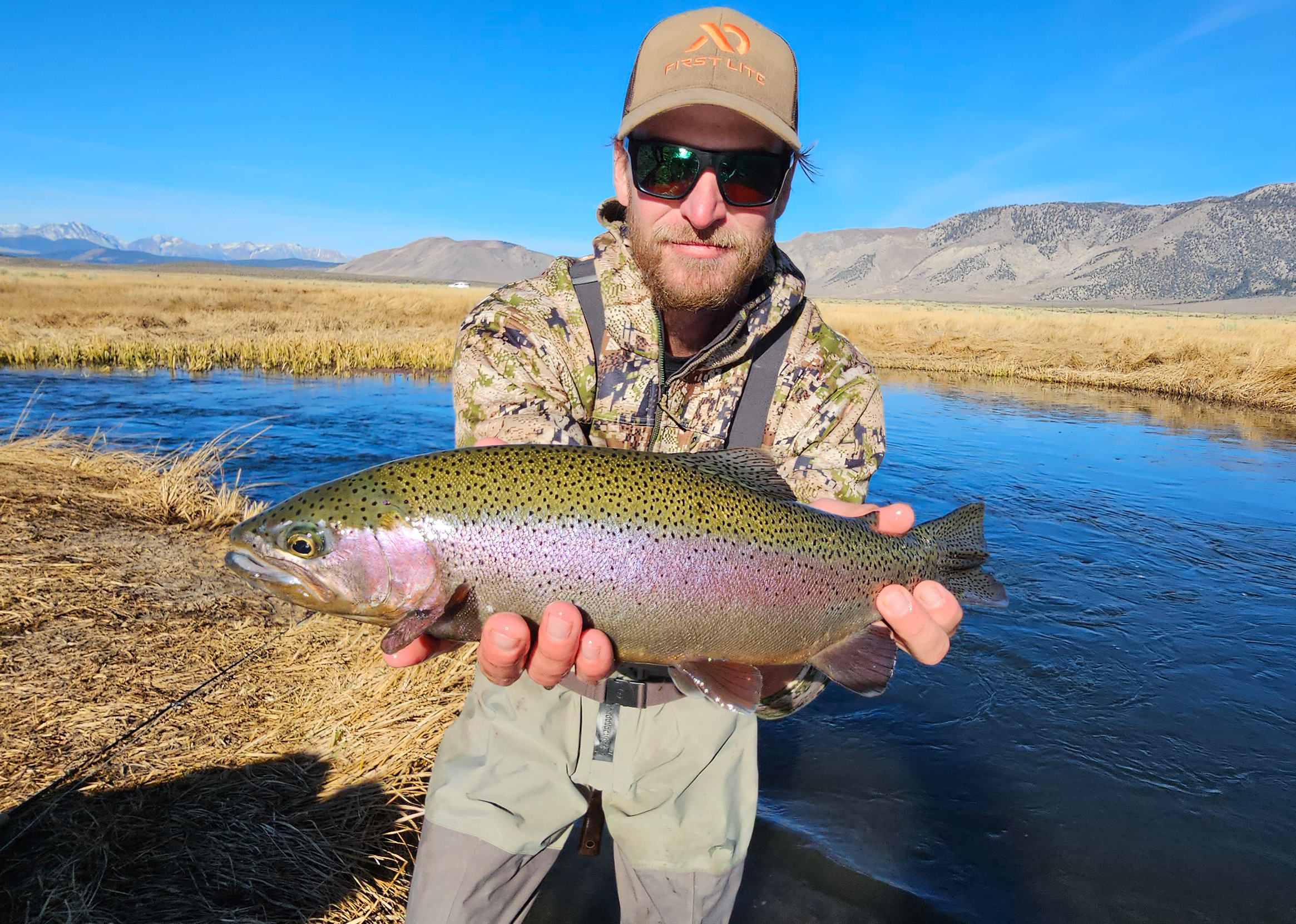 A man holding a massive rainbow trout on the Upper Owens River.