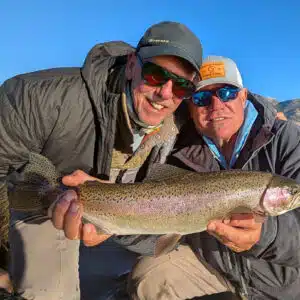 A couple of men holding a pair of brown trout from the Upper Owens River while fishing with an Eastern Sierra Fishing Guide.