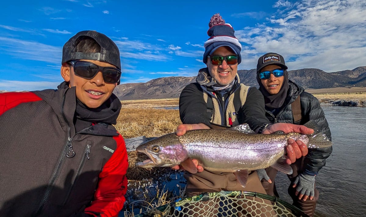 A fly fisherman holding a giant rainbow trout  on the Upper Owens River.