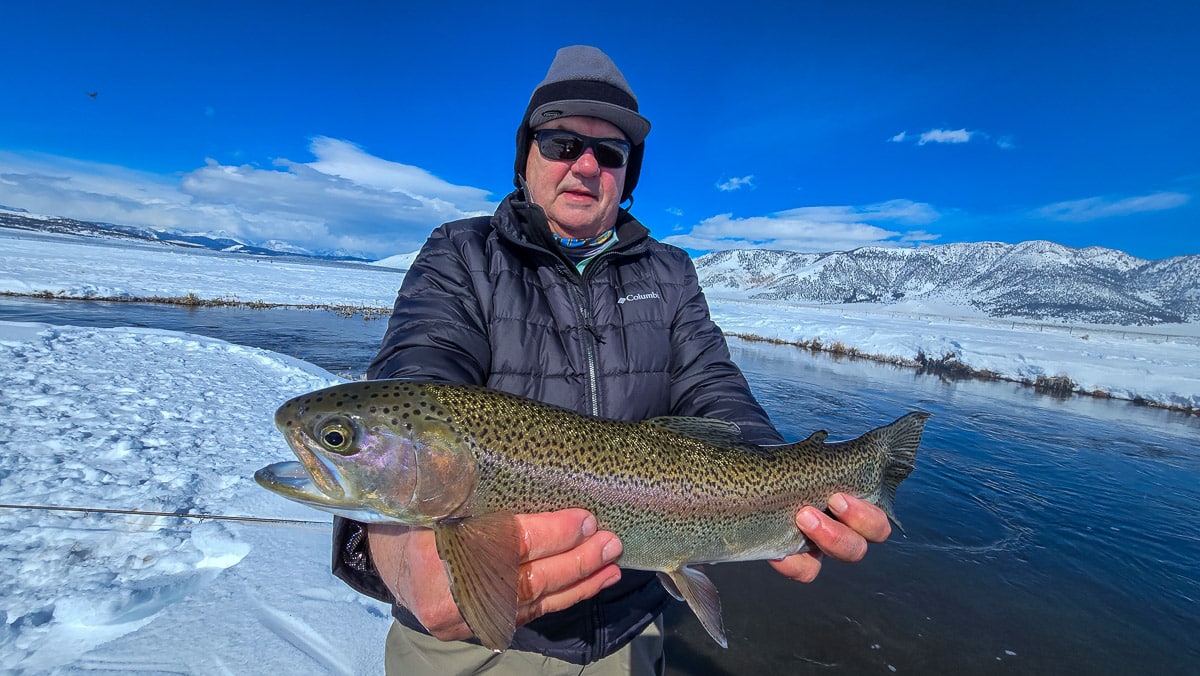 A pair of smiling fly fishermen holding a giant rainbow trout on the Upper Owens River near Mammoth Lakes, CA