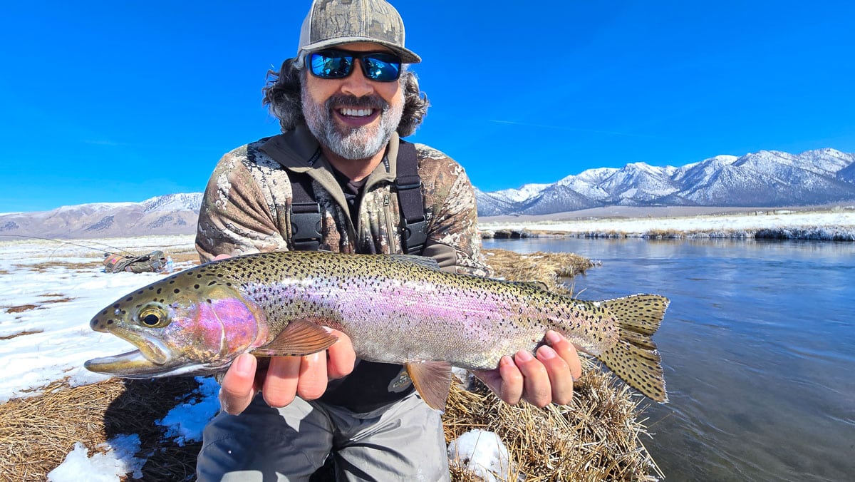 A pair of smiling fly fishermen holding a giant rainbow trout on the Upper Owens River near Mammoth Lakes, CA