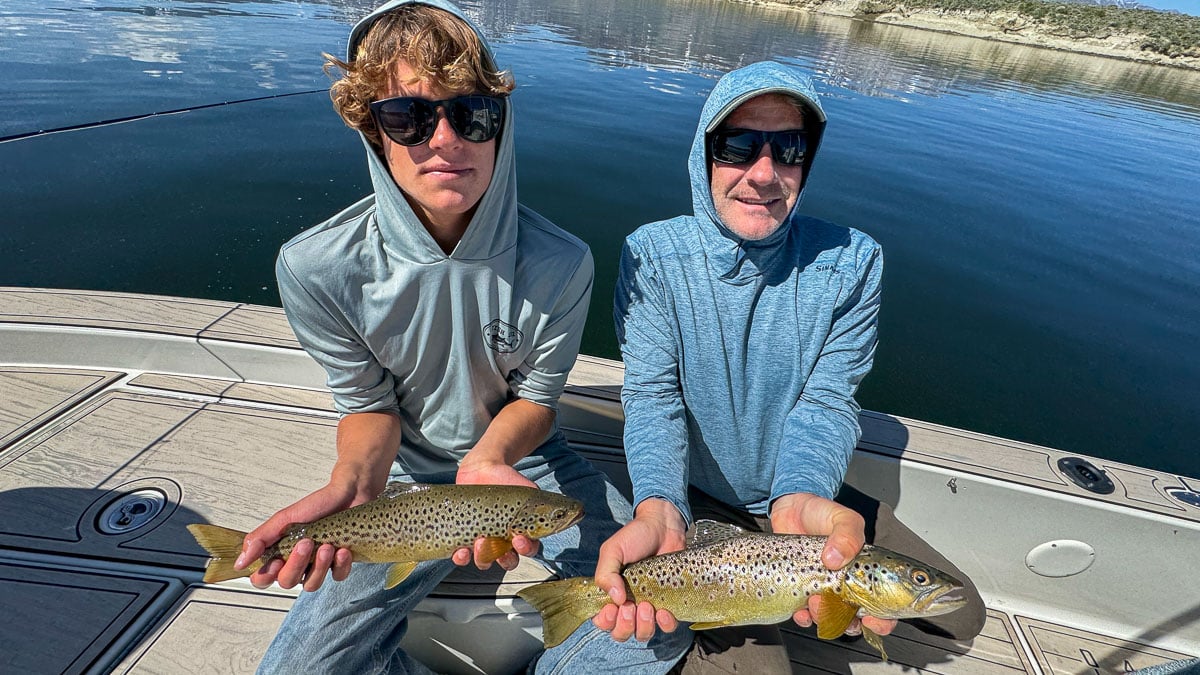 A pair of fly fisherman holding a pair of large brown trout on Crowley Lake near Mammoth Lakes, CA