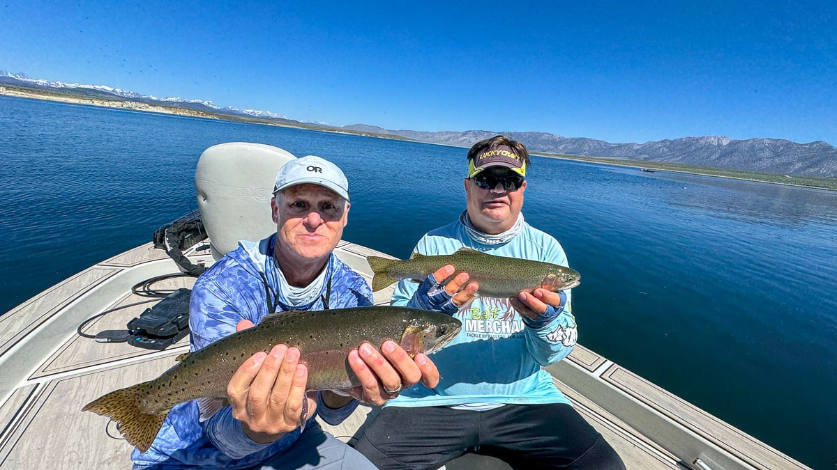 A pair of fly fisherman holding large rainbow trout on Crowley Lake near Mammoth Lakes, CA