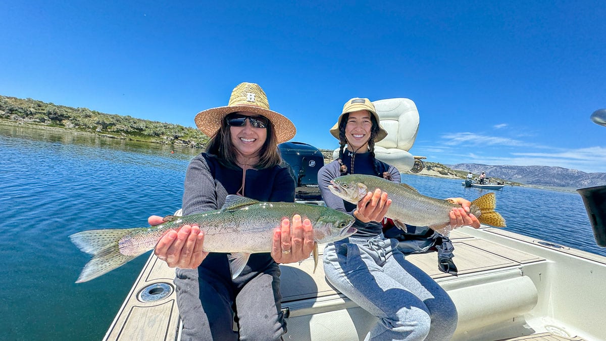 A fly fisherman holding a large cutthroat trout on Crowley Lake near Mammoth Lakes, CA