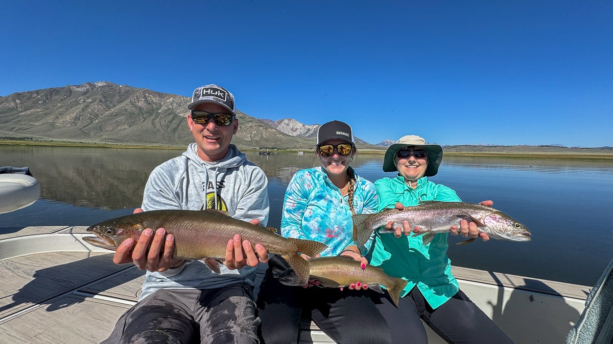 A fly fisherman holding a large rainbow trout on Crowley Lake.
