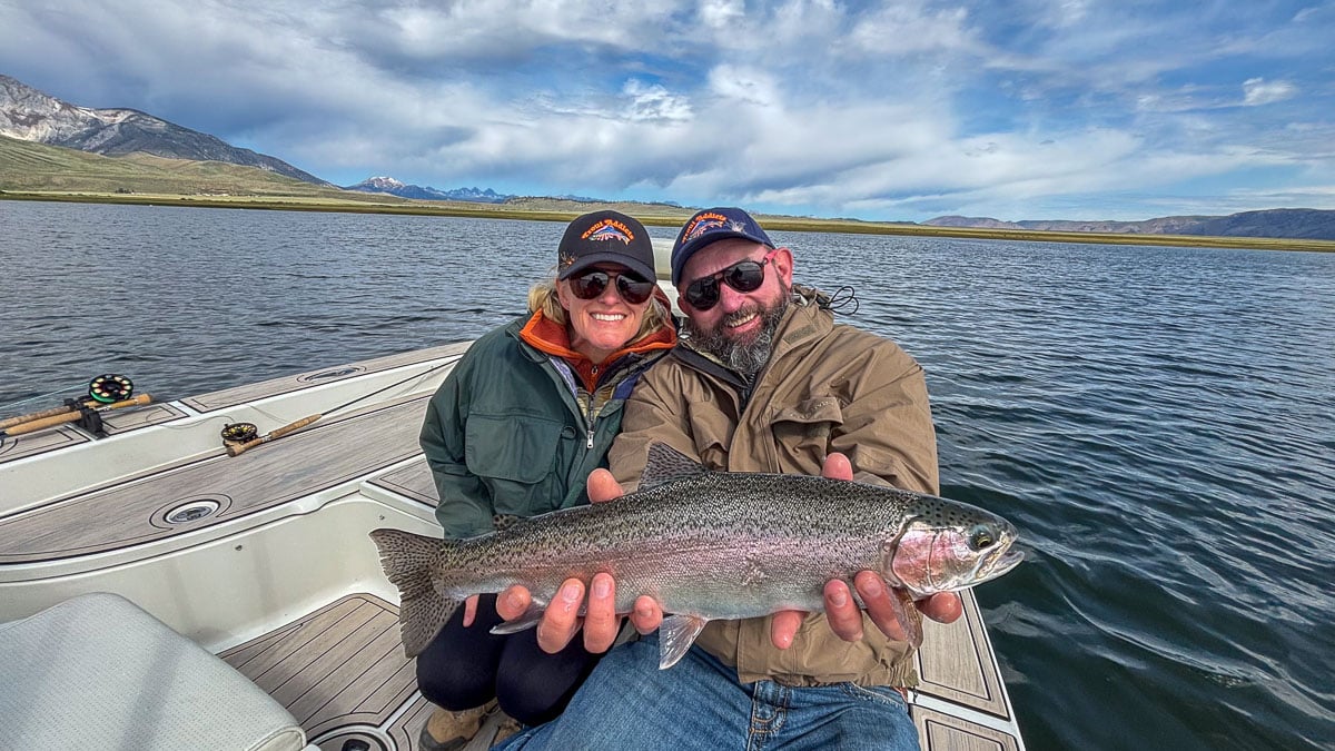 A fly fisherman holding a large brown trout on Crowley Lake near Mammoth Lakes, CA