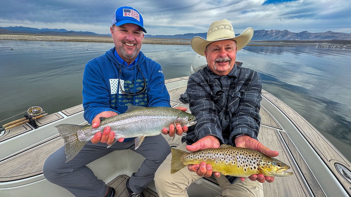 A fly fisherwoman holding a large rainbow trout on Crowley Lake near Mammoth Lakes, CA
