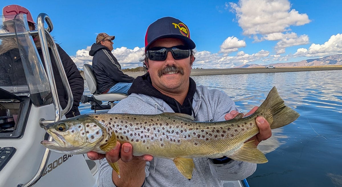 A fly fisherwoman holding a large rainbow trout on Crowley Lake near Mammoth Lakes, CA