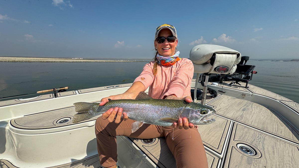A fly fisherman holding a large cutthroat trout on Crowley Lake near Mammoth Lakes, CA