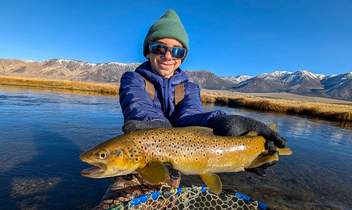 A fly fisheman holding a large rainbow trout on the Upper Owens River near Mammoth Lakes, CA