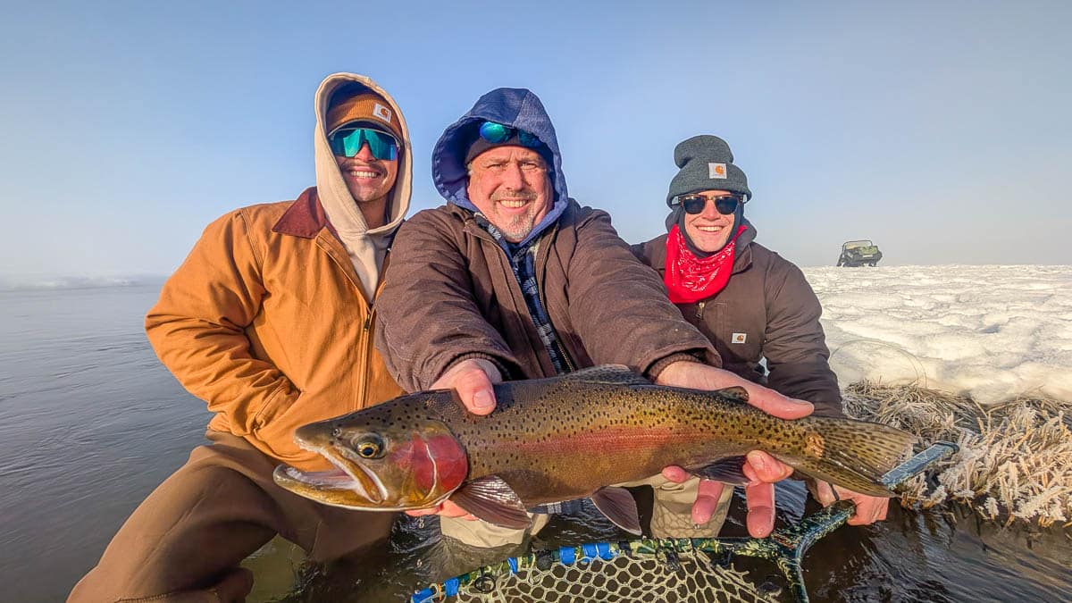 A fly fisheman holding a large rainbow trout on the Upper Owens River near Mammoth Lakes, CA
