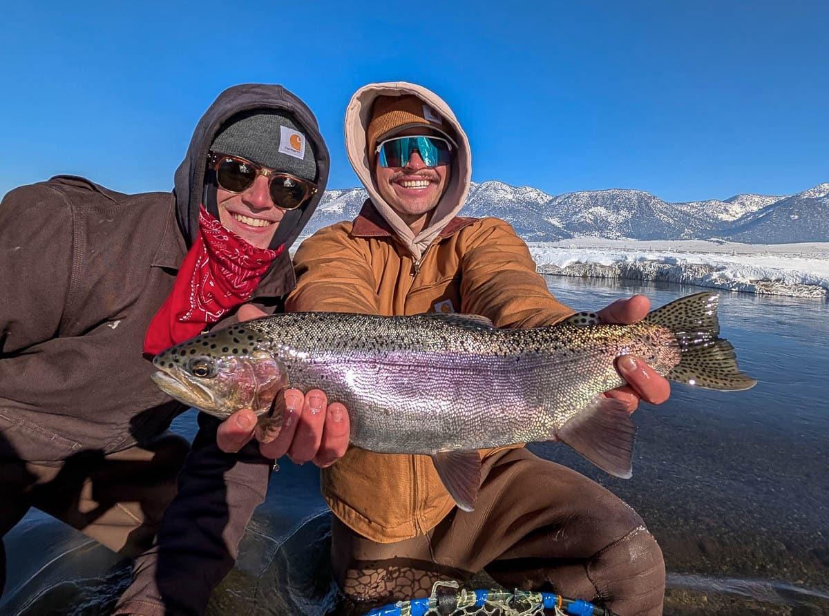 A fly fisheman holding a large rainbow trout on the Upper Owens River near Mammoth Lakes, CA