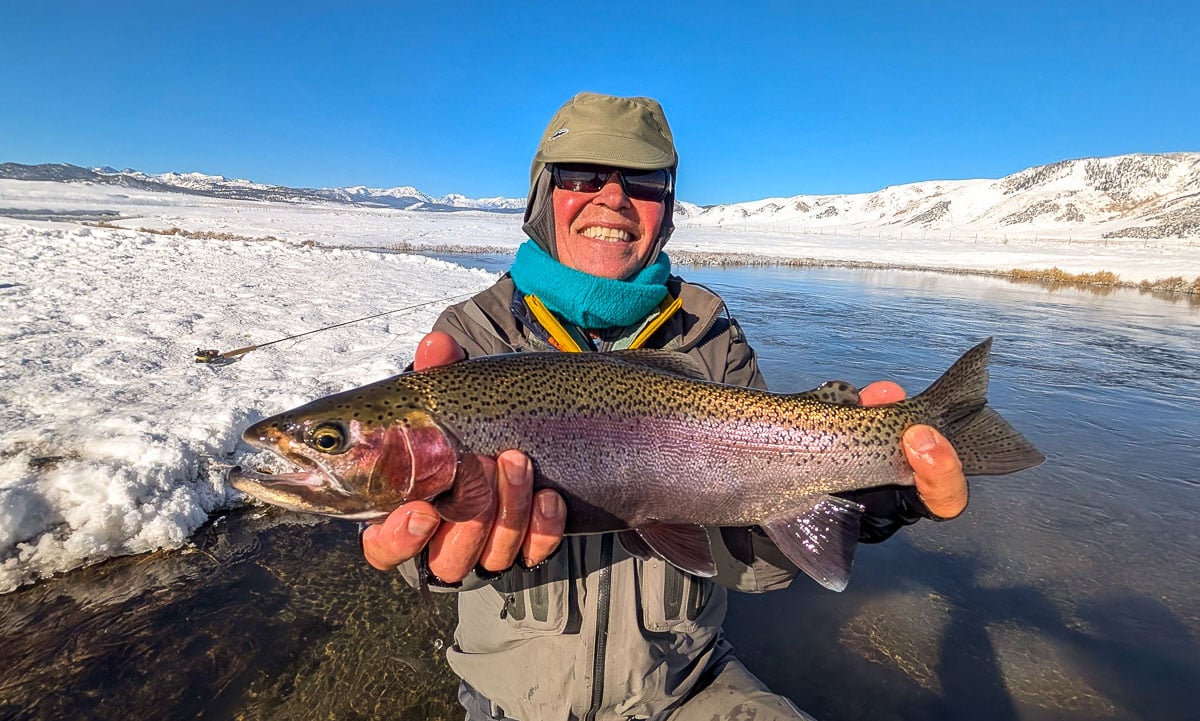 A fly fisheman holding a large rainbow trout on the Upper Owens River near Mammoth Lakes, CA