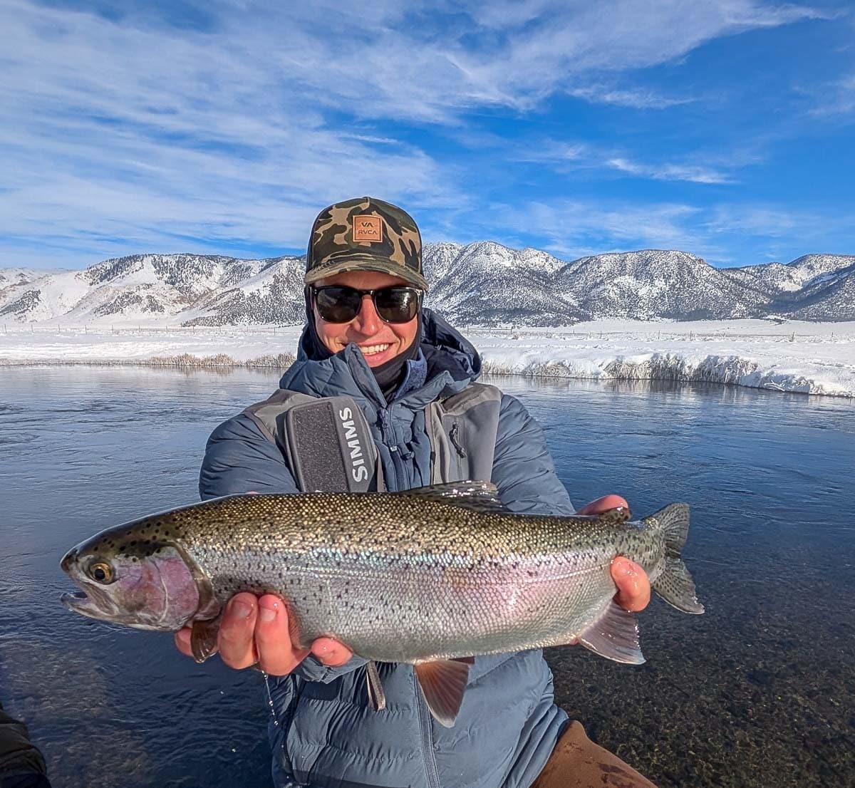 A fly fisheman holding a large rainbow trout on the Upper Owens River near Mammoth Lakes, CA