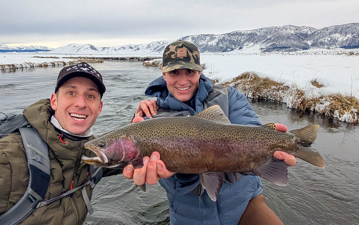 A fly fisheman holding a large rainbow trout on the Upper Owens River near Mammoth Lakes, CA
