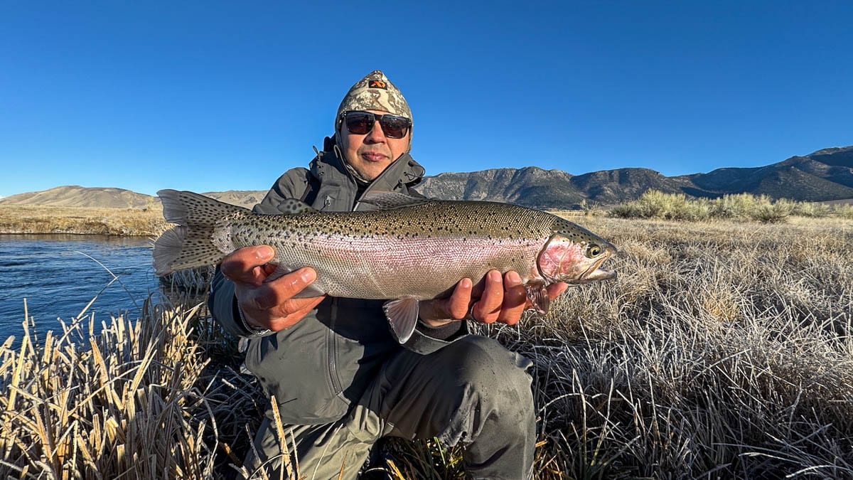 A fly fisheman holding a large rainbow trout on the Upper Owens River near Mammoth Lakes, CA