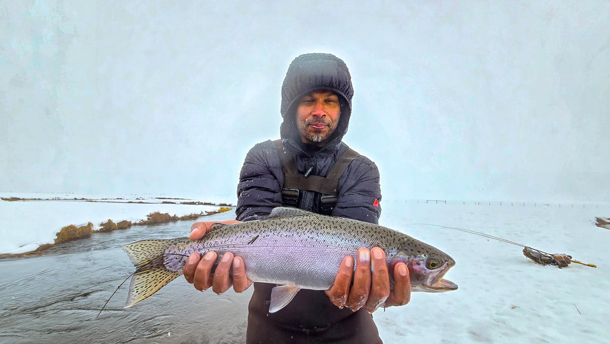 A fly fisheman holding a large rainbow trout on the Upper Owens River near Mammoth Lakes, CA