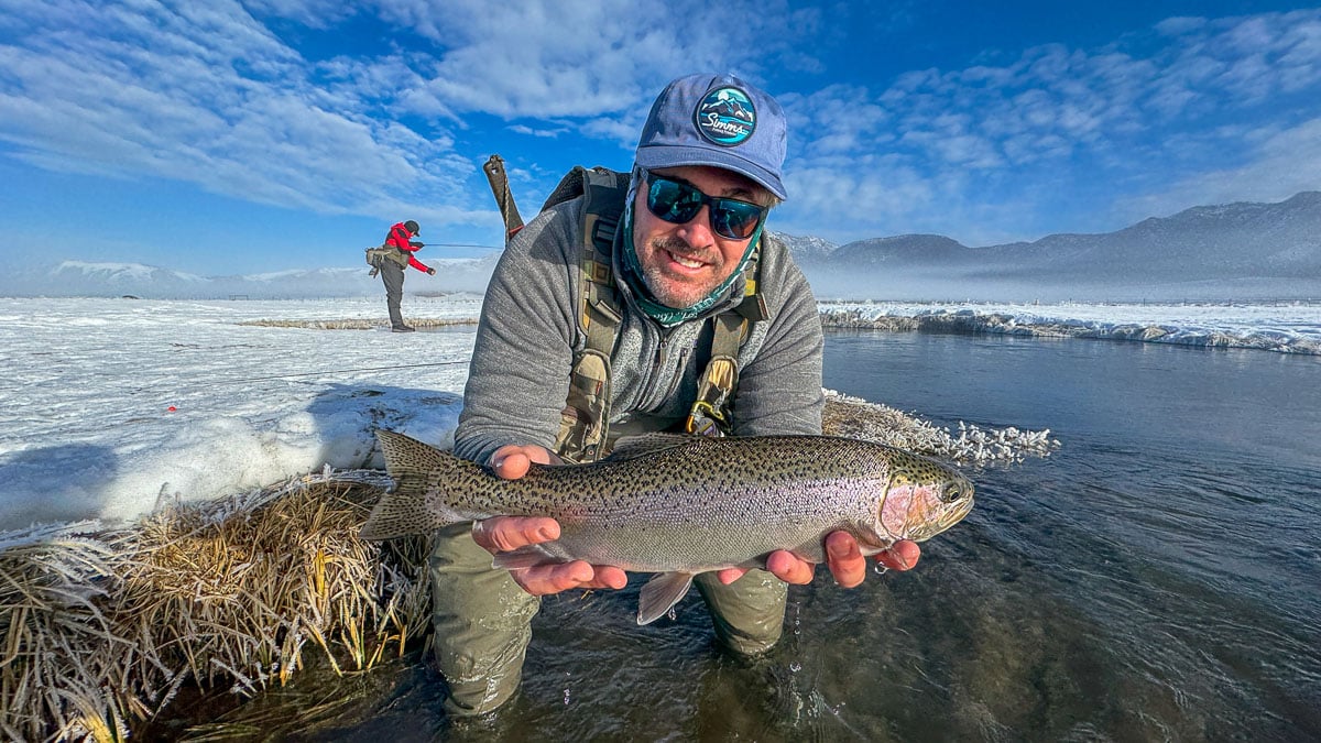 A fly fisheman holding a large rainbow trout on the Upper Owens River near Mammoth Lakes, CA