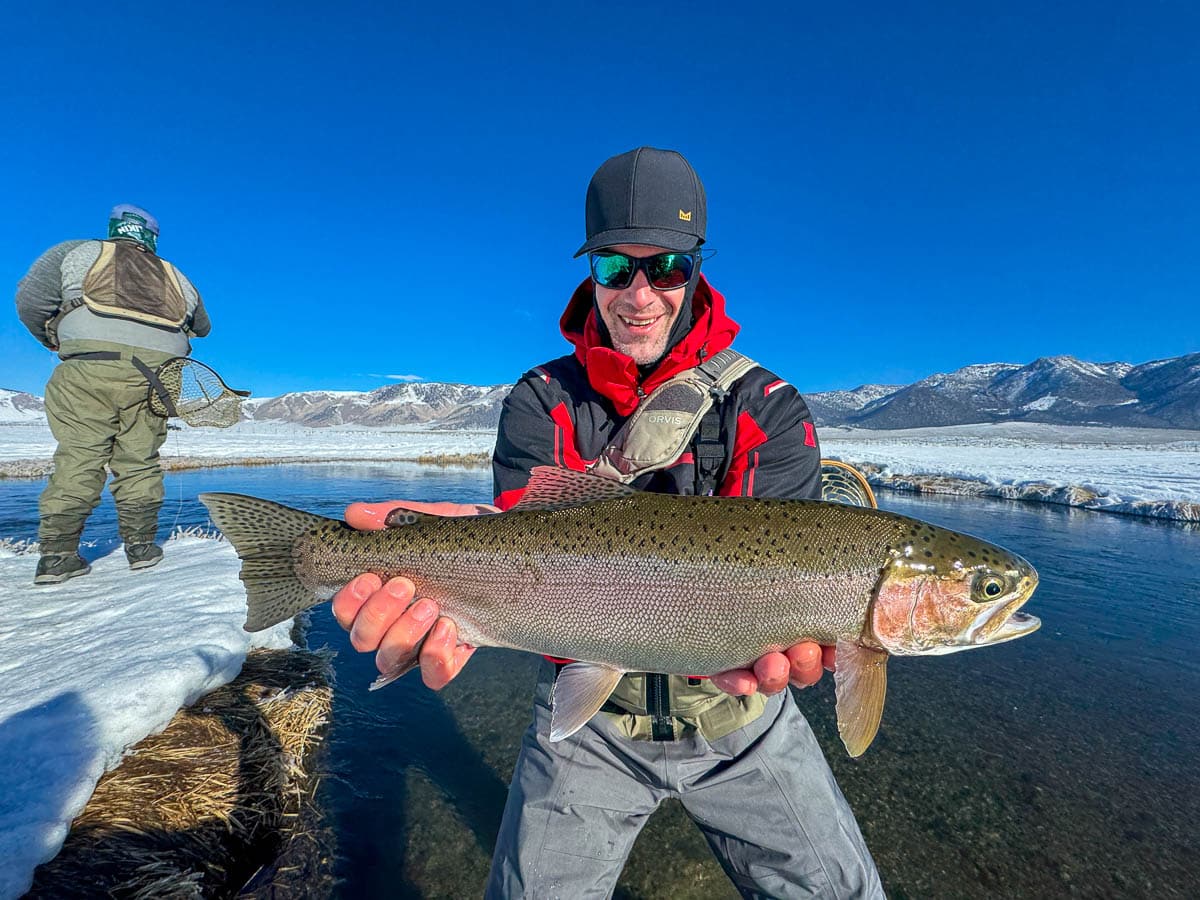 A fly fisheman holding a large rainbow trout on the Upper Owens River near Mammoth Lakes, CA