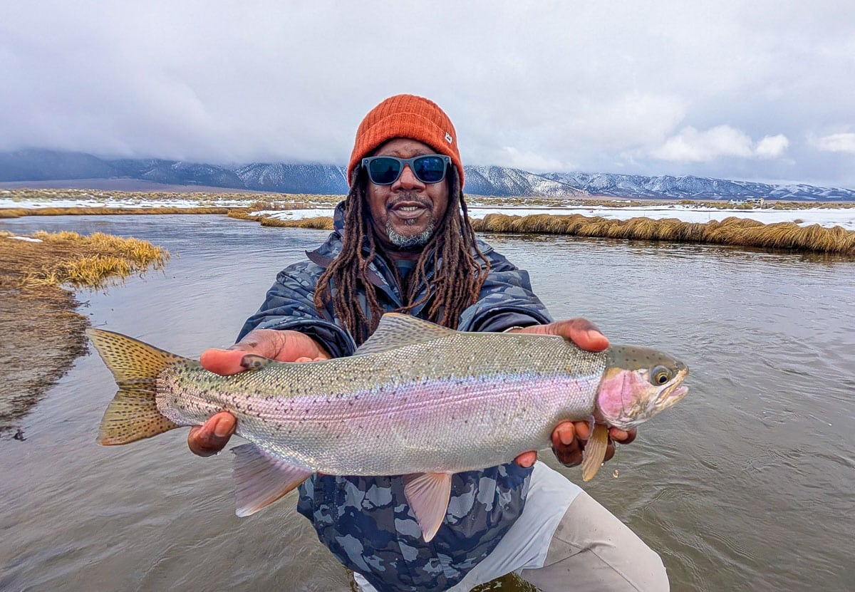 A fly fisheman holding a large rainbow trout on the Upper Owens River near Mammoth Lakes, CA