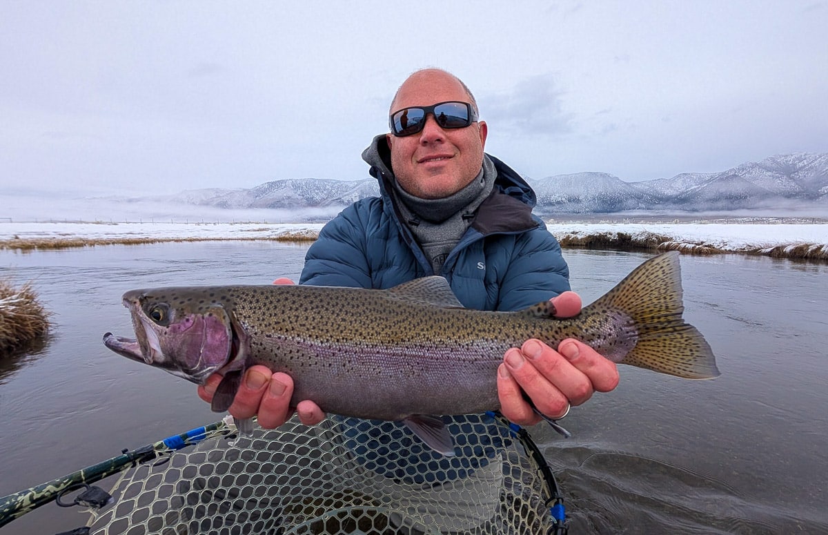 A fly fisheman holding a large brown trout on the Lower Owens River near Bishop, CA