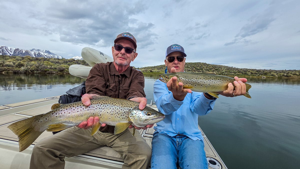 A fly fisherman holding a large rainbow trout on the Upper Owens River near Mammoth Lakes, CA
