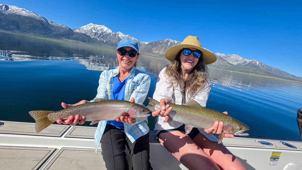 A fly fisherman holding a large rainbow trout on the Upper Owens River near Mammoth Lakes, CA
