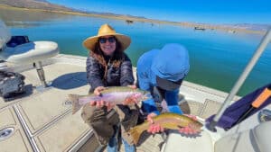 Two fly fishermen holding a large rainbow and cutthroat trout from Crowley Lake near Mammoth Lakes, CA