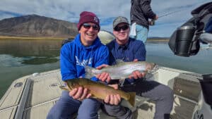 Two fly fishermen holding a large rainbow and cutthroat trout from Crowley Lake near Mammoth Lakes, CA