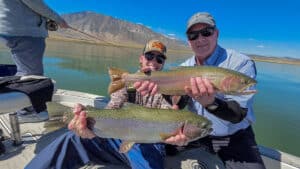 Two fly fishermen holding a large rainbow and cutthroat trout from Crowley Lake near Mammoth Lakes, CA