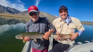 Two fly fishermen holding a large rainbow and cutthroat trout from Crowley Lake near Mammoth Lakes, CA